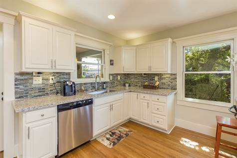 Spacious entertainers Kitchen, with newly installed Oak Hardwood Floors, freshly painted Cabinets, new Granite Counter Tops, new Under Cabinet Lighting, new Tile Back Splash and built-in Bose Speakers. 