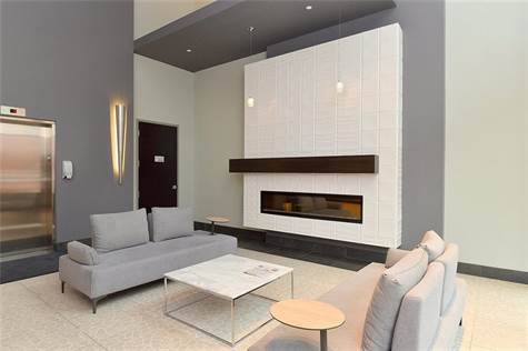 Beautiful lobby with fireplace, seating & access to elevator.