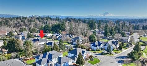 The entrance to the neighborhood is a wide street, lined with trees and white fencing, and features stunning views of Mt. Rainier.  