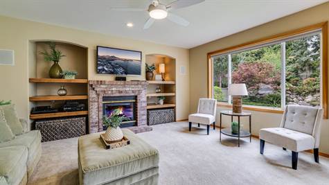 Family room with built in shelving on either side of the gas fireplace.