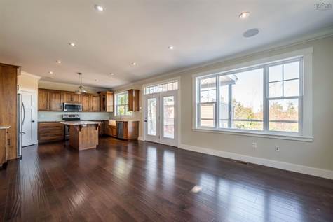The open floor plan of the great room allows for a beautifully designed custom walnut kitchen, pantry, dining area and main floor family room