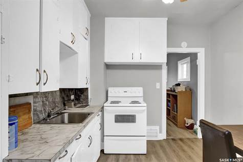 Kitchen with backsplash, light wood-type flooring, electric stove, and white cabinetry
