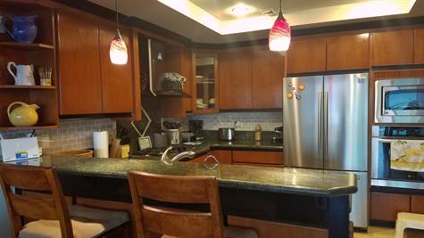 Kitchen has granite countertops and beautiful wood cabinetry